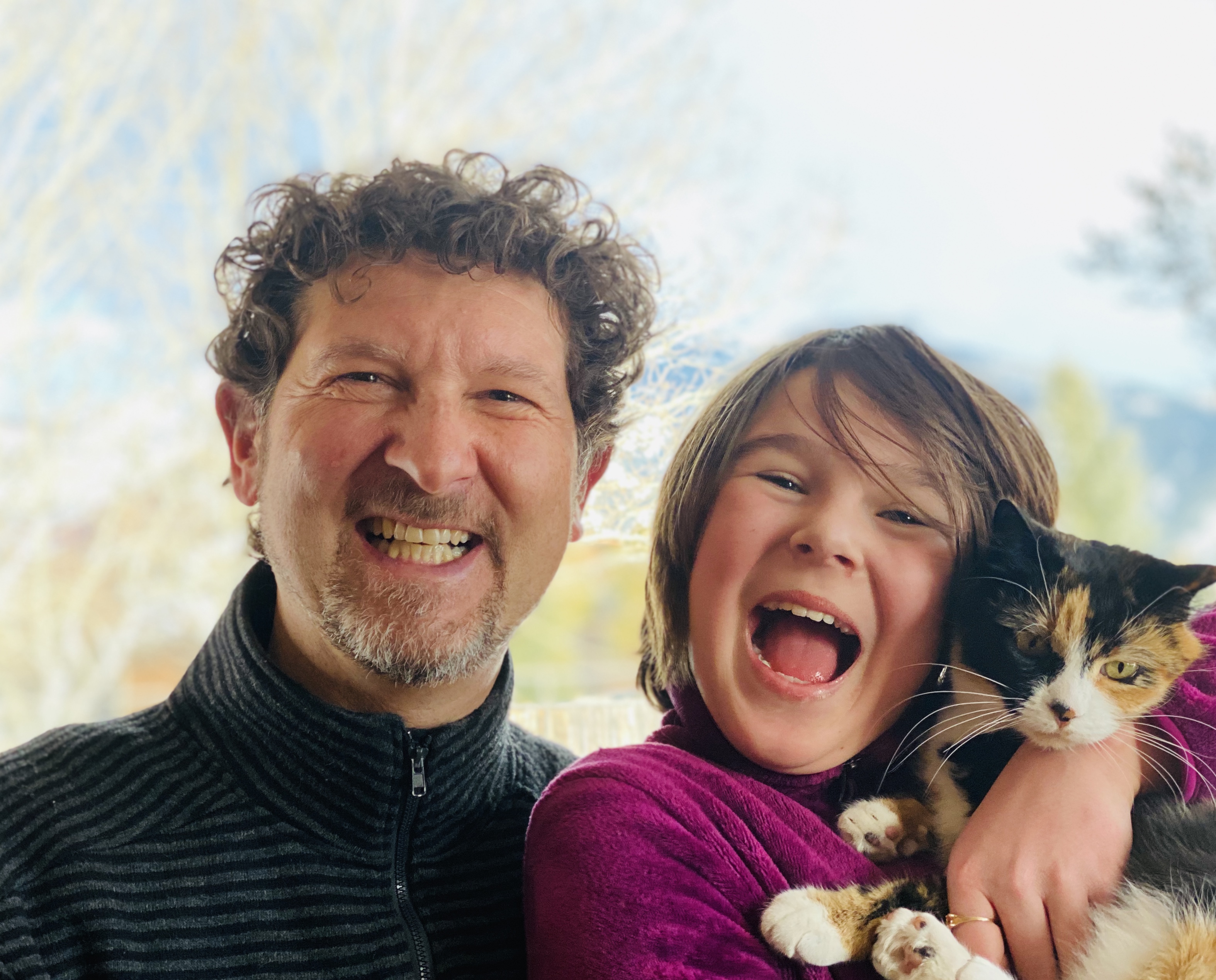 Ephie and Blue laughing, holding their calico cat